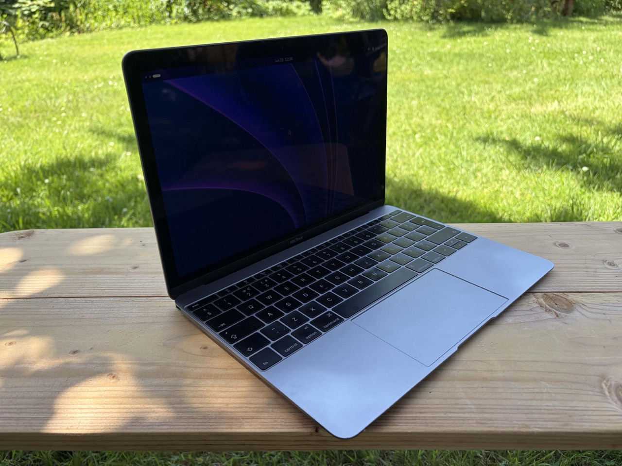 2015 Macbook on a bench, sweltering in the English sunshine